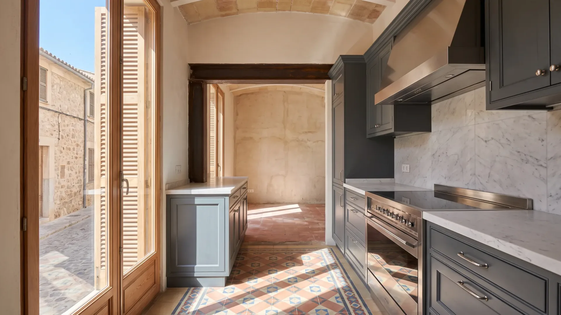 Zweizeilige Küche mit grau lackierten Küchenmöbeln, einer Küchenrückwand aus Marmor und einem Herd, Zementfliesen und hohe Türen