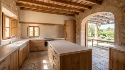 Eichenküche mit einer breiten Kücheninsel und freien Wegen, ein Steinboden und eine Bogenöffnung zu einer Terrasse unter einer Pergola